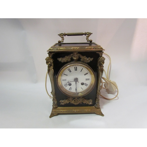 4255 - A French mantel clock, brass cased with figural mounts, electric movement later added