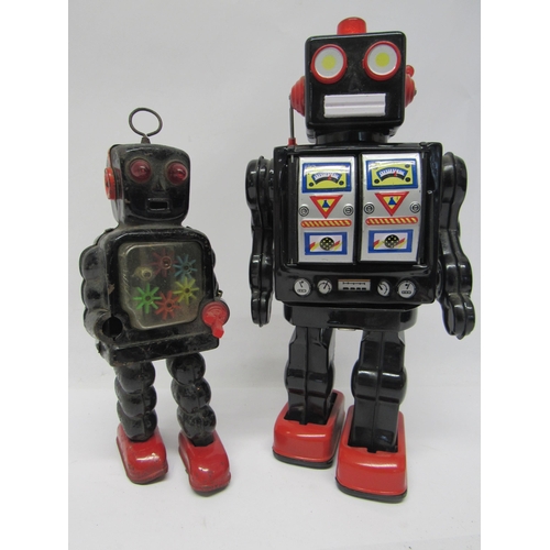 7078 - A battery operated tinplate robot with black body and red feet, twin door chest cavity opening to re... 