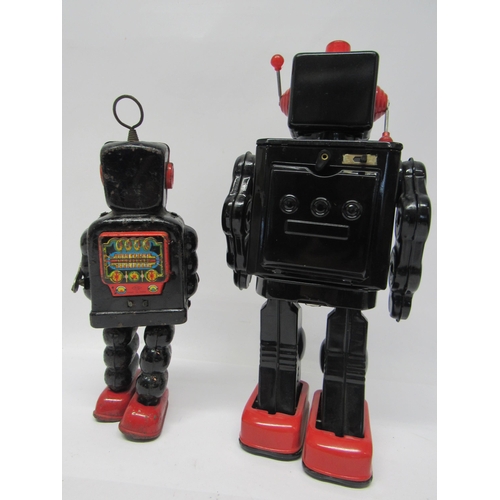 7078 - A battery operated tinplate robot with black body and red feet, twin door chest cavity opening to re... 