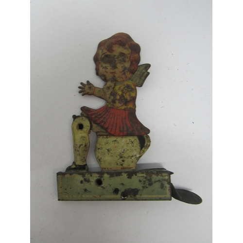 7192 - A 1920s German litho-printed clicker toy as a girl on potty, the girl raising up from the bed pan fo... 