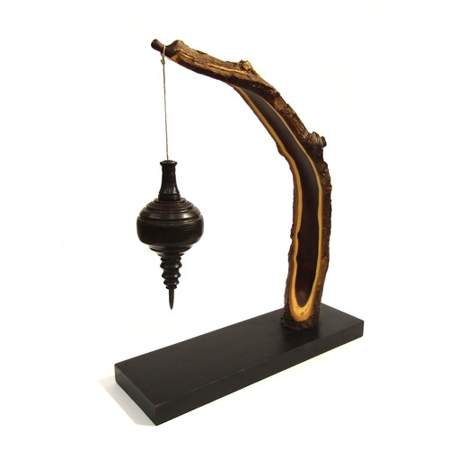 7544 - RICHARD CHAPMAN (b.1951) An Ebony and Laburnum sculpture, the Laburnum arching arm holding a turned ... 