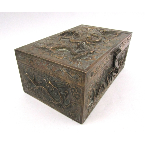 5019 - A cast brass casket with raised decoration bearing dragons, velvet lined interior with six character... 