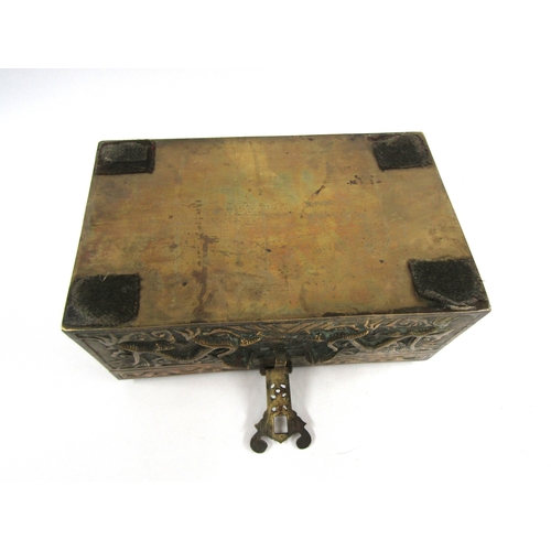 5019 - A cast brass casket with raised decoration bearing dragons, velvet lined interior with six character... 