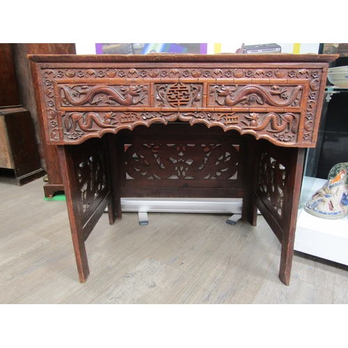 5020 - A 19th Century Chinese carved hardwood folding writing table and stool, allover carved decoration of... 