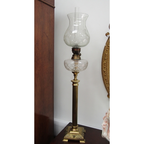 5475 - A French clear glass and brass column form oil lamp. The shade with etched leaf design the reservoir... 