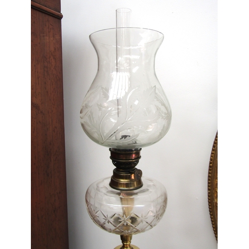 5475 - A French clear glass and brass column form oil lamp. The shade with etched leaf design the reservoir... 