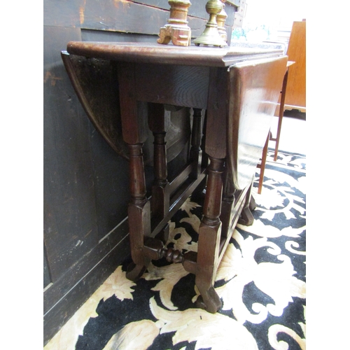 5508 - An 18th Century (Queen Anne Period) pegged oak oval top gate-leg table, the rising leaves over a sin... 