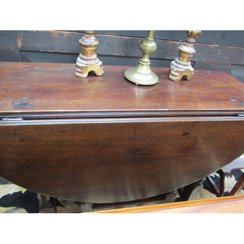 5508 - An 18th Century (Queen Anne Period) pegged oak oval top gate-leg table, the rising leaves over a sin... 