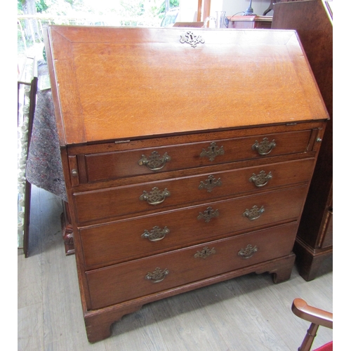 5513 - A Georgian oak bureau of small proportions.  The fall front opening to reveal a fitted pigeon hole d... 