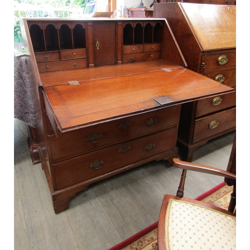 5513 - A Georgian oak bureau of small proportions.  The fall front opening to reveal a fitted pigeon hole d... 