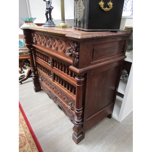 5519 - A 19th Century oak breakfront chest of four drawers having carved and turned decoration with turned ... 