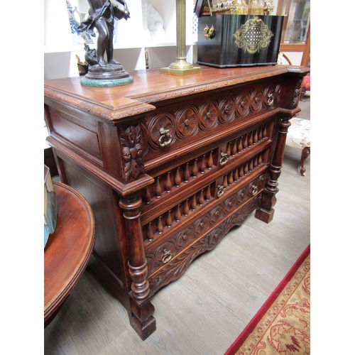 5519 - A 19th Century oak breakfront chest of four drawers having carved and turned decoration with turned ... 