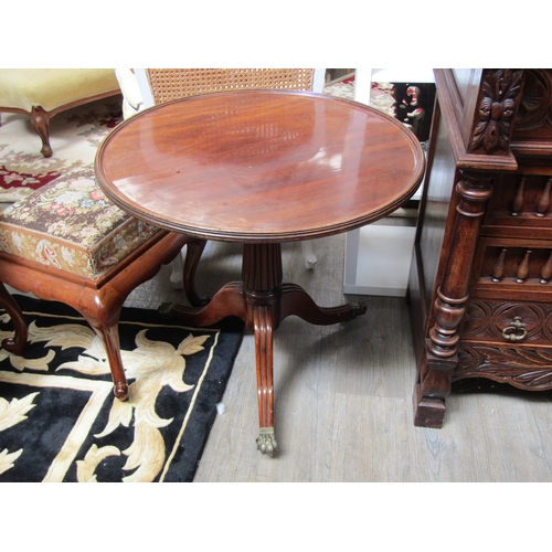 5521 - A 19th Century mahogany wine table, the dished top over a fluted column to a tripod base with brass ... 