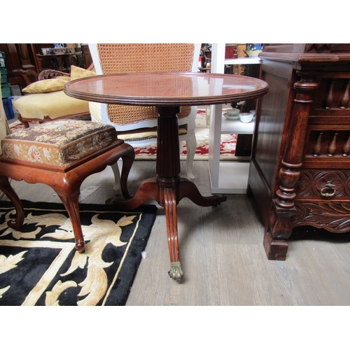 5521 - A 19th Century mahogany wine table, the dished top over a fluted column to a tripod base with brass ... 