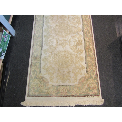 A silk cream ground runner rug with pale green border, 270cm x 76cm