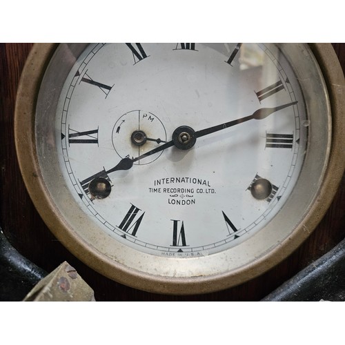 5692 - An early 20th Century oak cased clocking-in clock, the case with inset enamel Roman dial signed The ... 