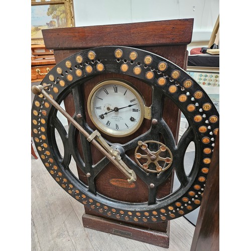 5692 - An early 20th Century oak cased clocking-in clock, the case with inset enamel Roman dial signed The ... 