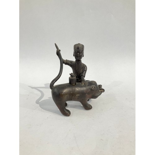 5058 - A bronze figural incense burner as a man holding the tail of a boar, 12.5cm high