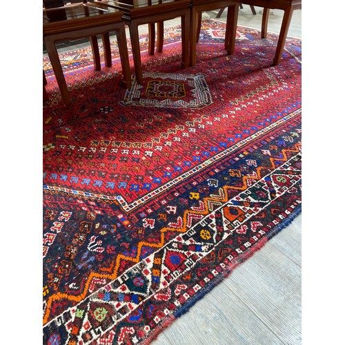 5696 - An Afghan carpet, hand knotted wool with vibrant multicoloured design, central motif, multiple borde... 