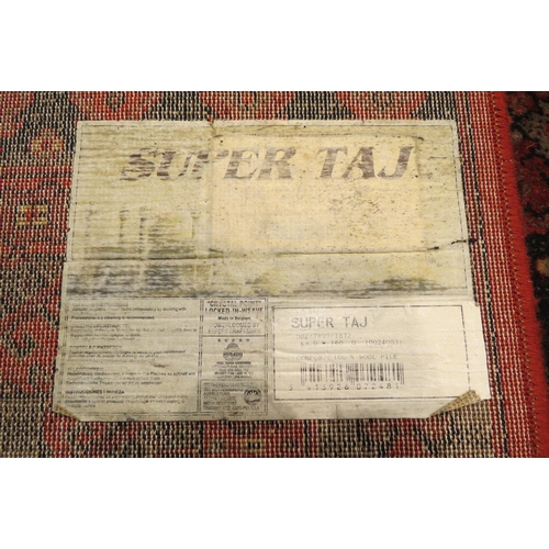 4003 - A Super Taj Belgian red ground wool rug with multiple borders, 156cm x 83cm