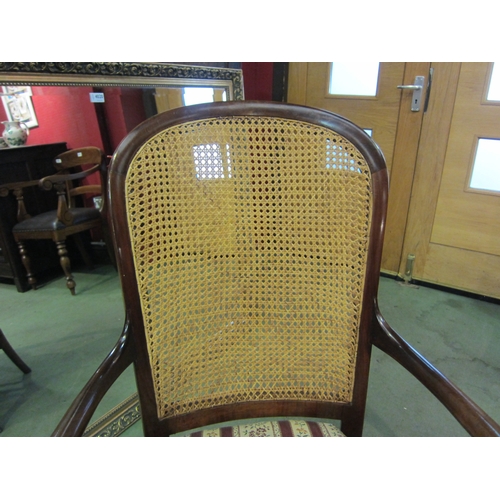 4013 - A late Victorian mahogany armchair, the caned back rest with bentwood armrests over ring turned outs... 