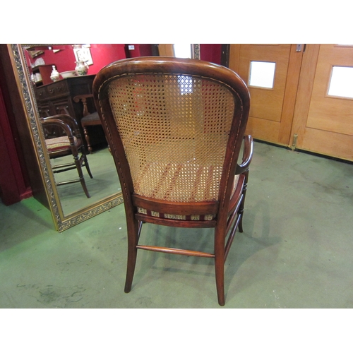 4013 - A late Victorian mahogany armchair, the caned back rest with bentwood armrests over ring turned outs... 