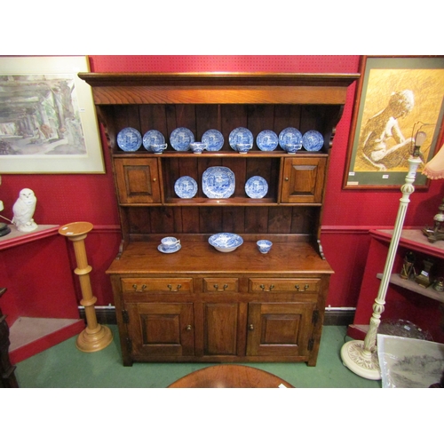 4042 - A George III style oak Welsh dresser with raised shelved back having two small cupboards over a thre... 