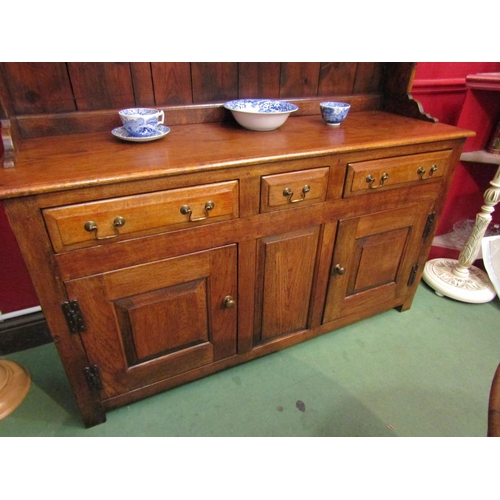4042 - A George III style oak Welsh dresser with raised shelved back having two small cupboards over a thre... 