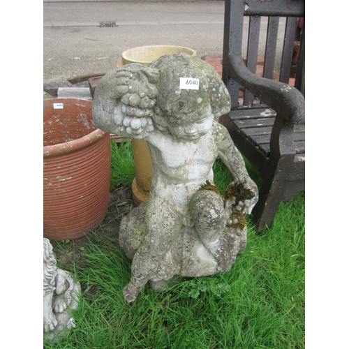 6048 - A weathered composition water outlet of cherub sitting on a jug holding grapes, 29