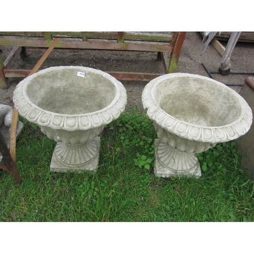 6058 - A pair of composition urns on socles, 18