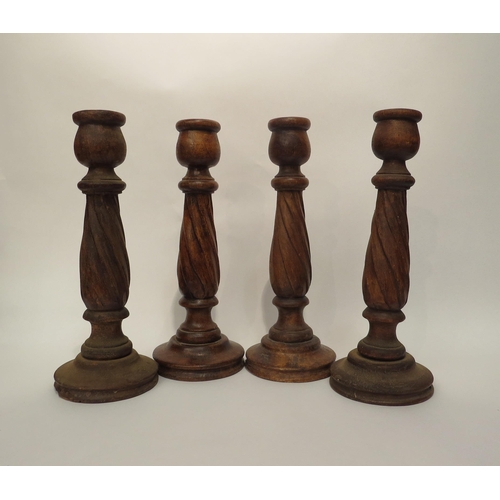 4137 - Four carved wooden candlesticks, 31.5cm tall