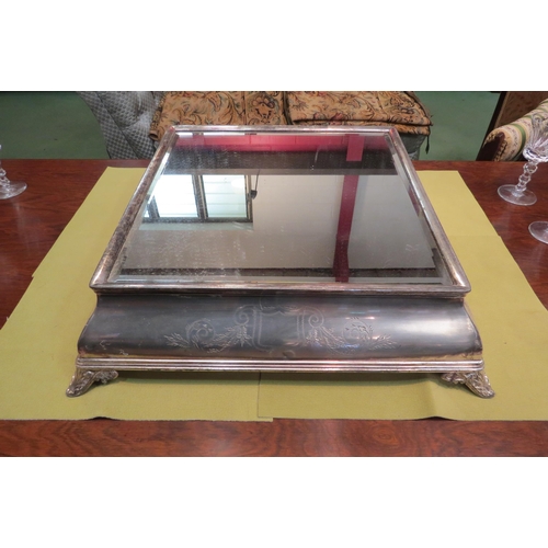 4151 - A plated wedding cake stand. Engraved decoration, bevelled mirrored glass top. Mirror plate 38cm x 3... 