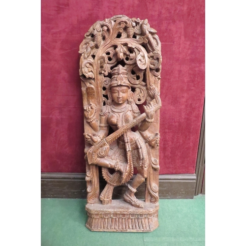 4177 - A well carved wood panel of deity playing a sitar, 90cm tall