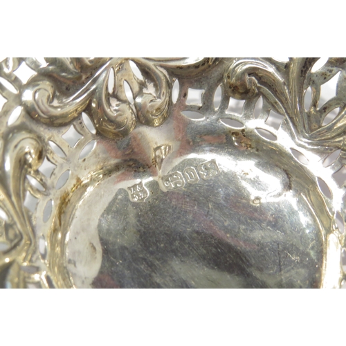 4304 - A silver heart shaped bonbon dish with pierced and embossed decoration on three ball feet.  Birmingh... 