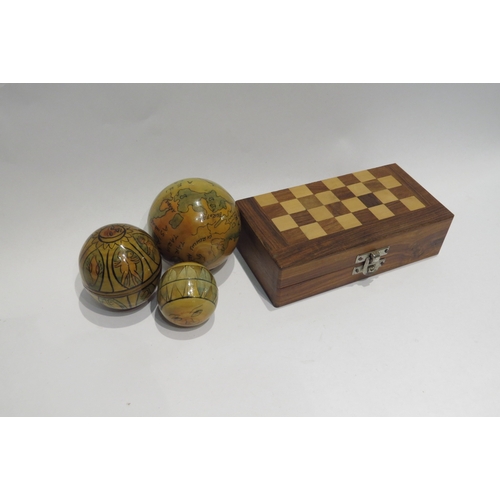 4340 - A small wooden travel chess set and a nesting globe set