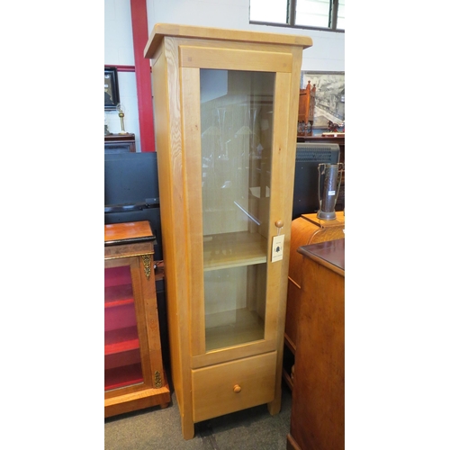 1074 - A light oak glazed single door cabinet with drawer below, 185cm tall x 60m wide x 42cm deep