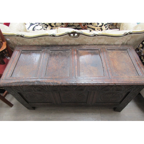 1084 - A 17th Century oak coffer, the four panel top over a heavily carved three panel front, spiral and fo... 