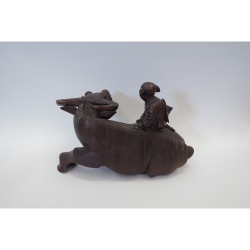 1102 - A Chinese carved wood water buffalo being ridden by a boy, 21cm tall