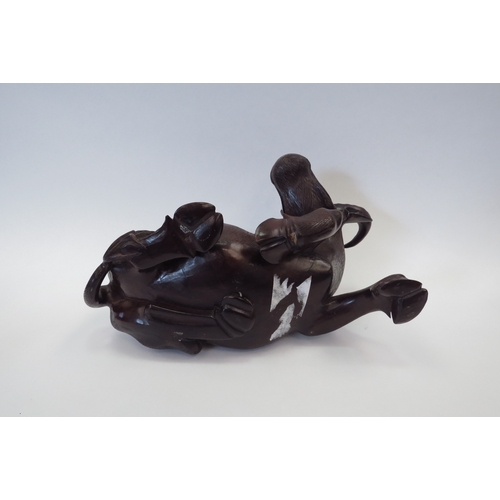 1102 - A Chinese carved wood water buffalo being ridden by a boy, 21cm tall