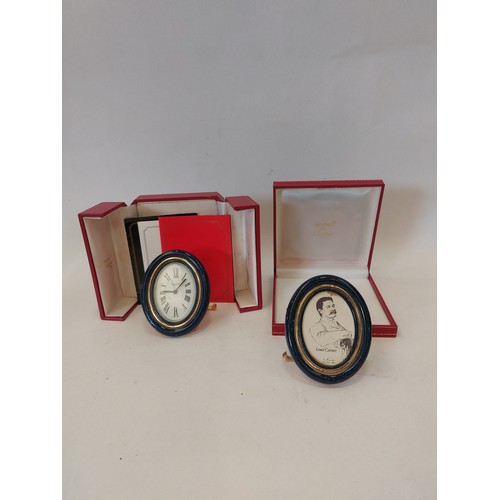 1332 - A Cartier travelling alarm clock, boxed, and a matching small oval photograph frame, boxed (2)