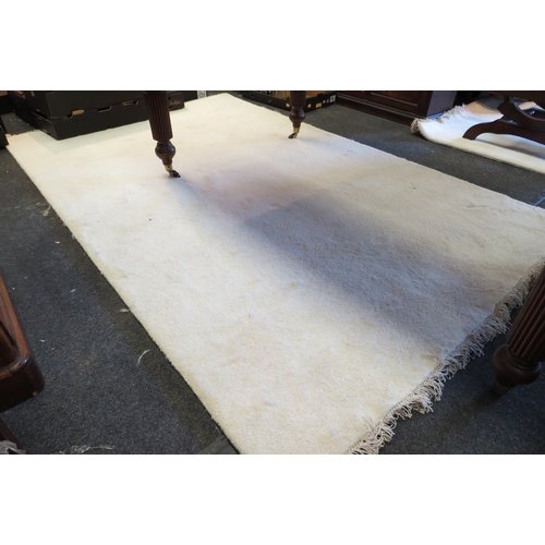 1422 - An Indian hand-knotted cream wool and cotton rug with tasselled ends, approximately 8ft x 5ft