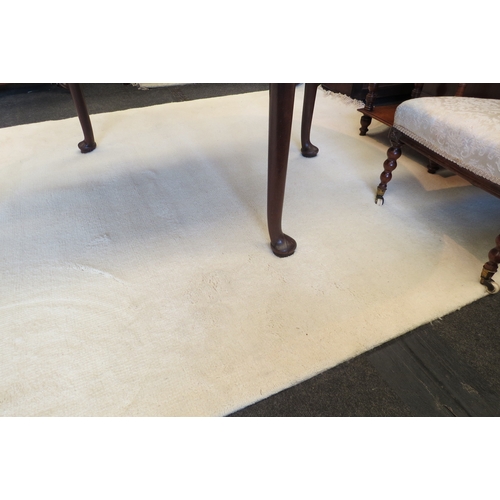 1421 - An Indian hand-knotted cream wool and cotton rug with tasselled ends, approximately 9ft x 6ft