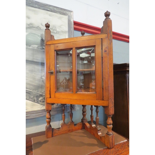 1075 - A pair of walnut corner cabinets of small proportions with bevelled glass doors, single inner shelf,... 