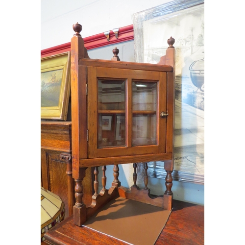 1075 - A pair of walnut corner cabinets of small proportions with bevelled glass doors, single inner shelf,... 