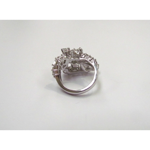 9150 - A diamond cluster ring, set with a sweep of 11 pear cut diamonds flanked by baguette cut diamond set... 