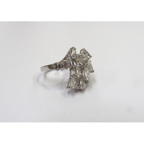 9150 - A diamond cluster ring, set with a sweep of 11 pear cut diamonds flanked by baguette cut diamond set... 