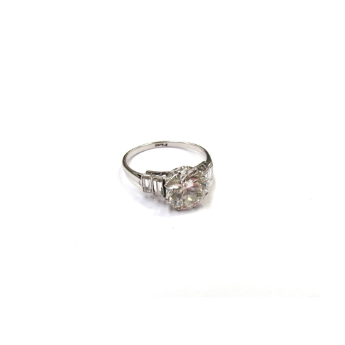 9300 - A platinum diamond solitaire 2.35ct approx flanked by two baguette diamonds. Size O, 3.3g