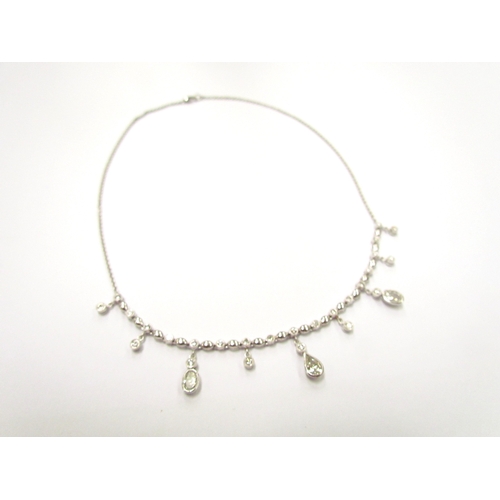 9420 - A white gold diamond set chandelier necklet, set with round, oval and pear shaped diamonds all in ru... 