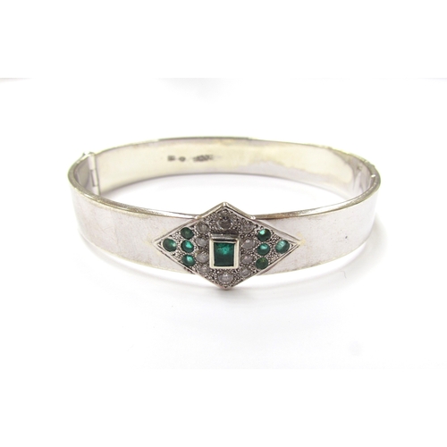 9284 - A white gold hinged bangle with centre lozenge set with diamonds and emeralds, stamped 