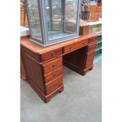 2220 - A stained pine twin pedestal desk with brown leather top